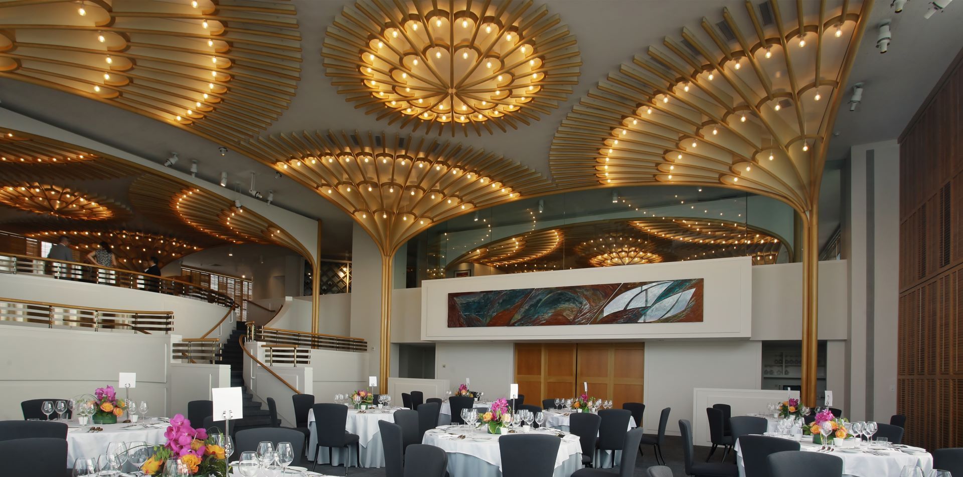 A large room with tables and chairs set up for a wedding reception