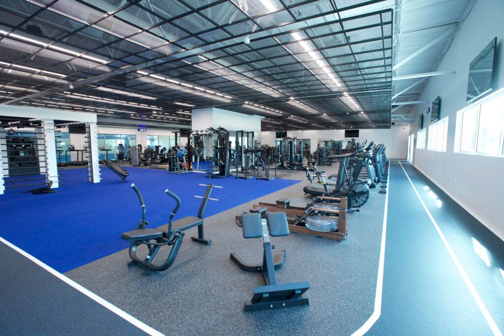A large gym with a blue track and lots of exercise equipment