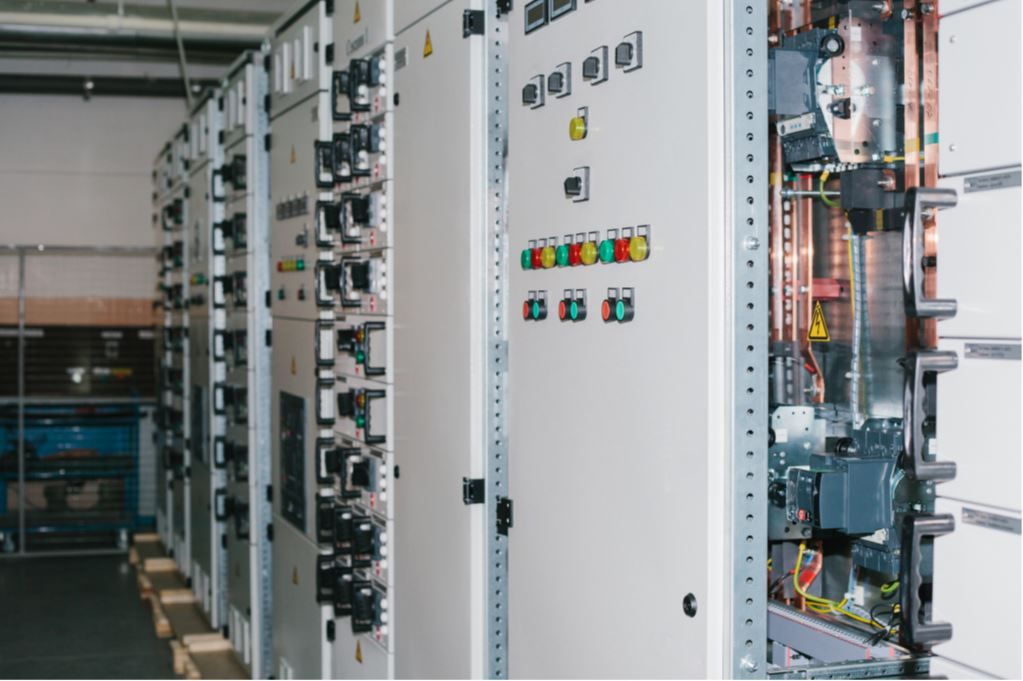 A row of electrical cabinets are lined up in a room.