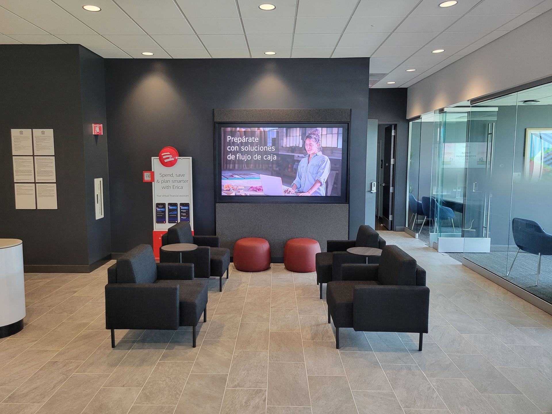 A waiting room with chairs and a large screen on the wall.