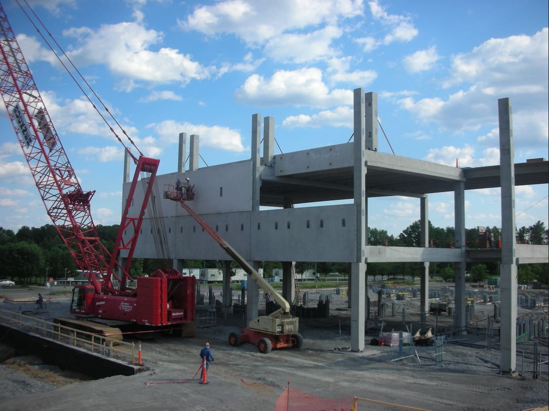 A red crane is working on a building under construction