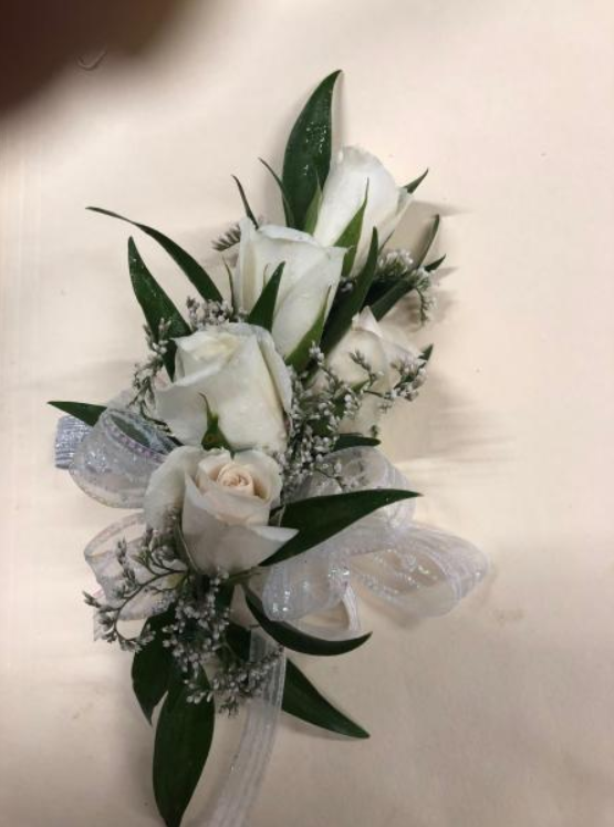 White floral bouquet with green leaves on a light background