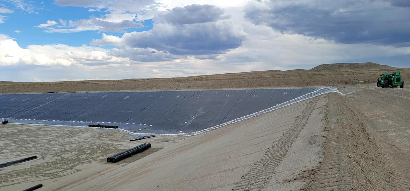 Side of reservior - sized dirt wall with black liner