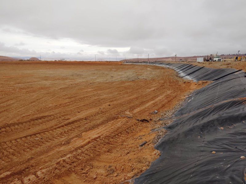 liner on bank of large empty pond