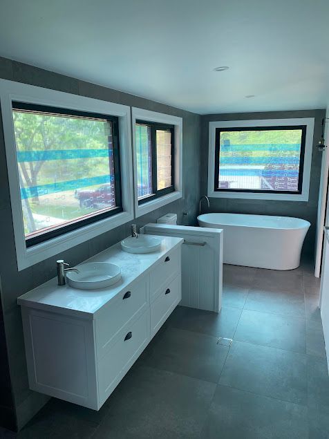 A New Bathroom With A Bath Tub And A Basin And New Large Windows — Lakesway Plumbing and Gas in Forster, NSW