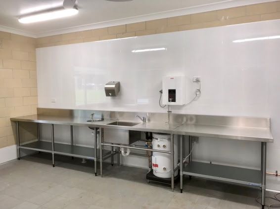 A Kitchen with Stainless Steel Tables, Sinks, and A Heater — Lakesway Plumbing and Gas in Forster, NSW