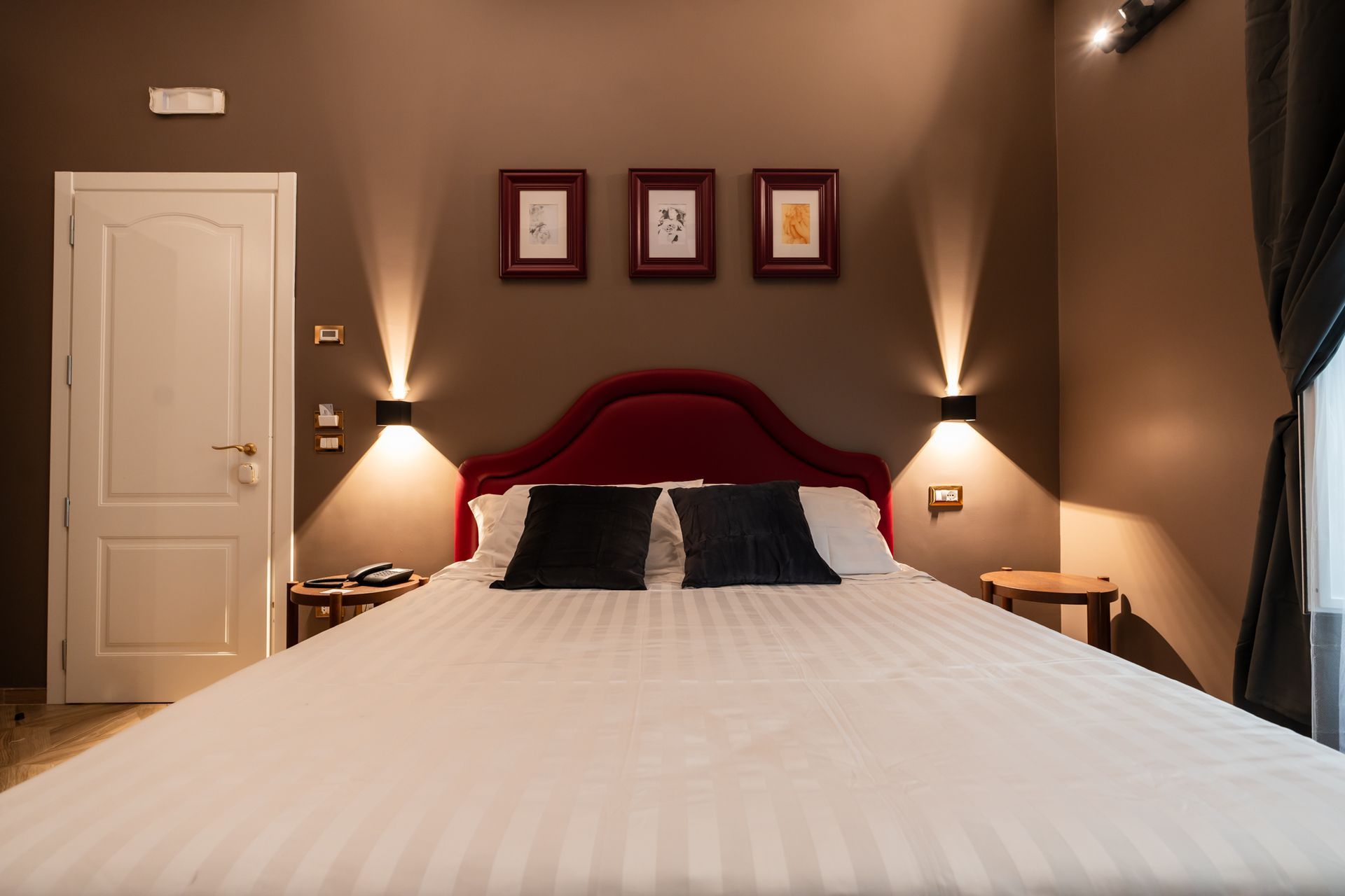 Camera da letto con letto, cassettiera, specchio e armadio. Sul letto sono presenti lenzuola e asciugamani bianchi.
