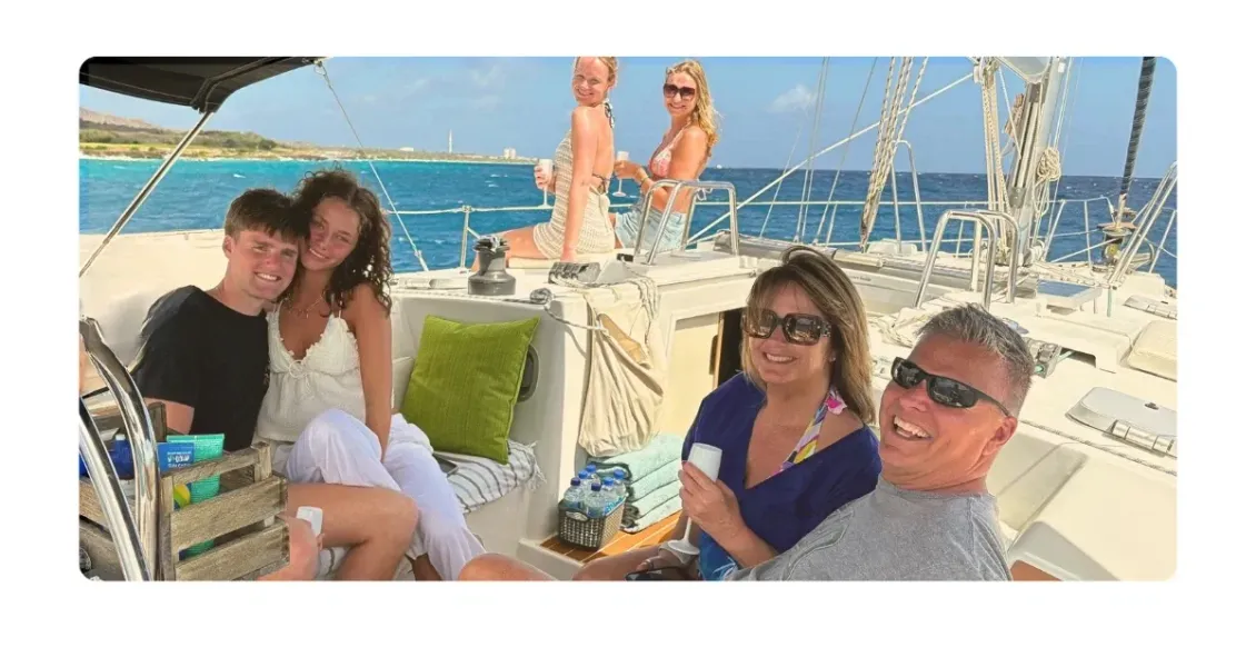 Galaxie at sunset cruise on Caribbean Sea with happy family in shaded cockpit