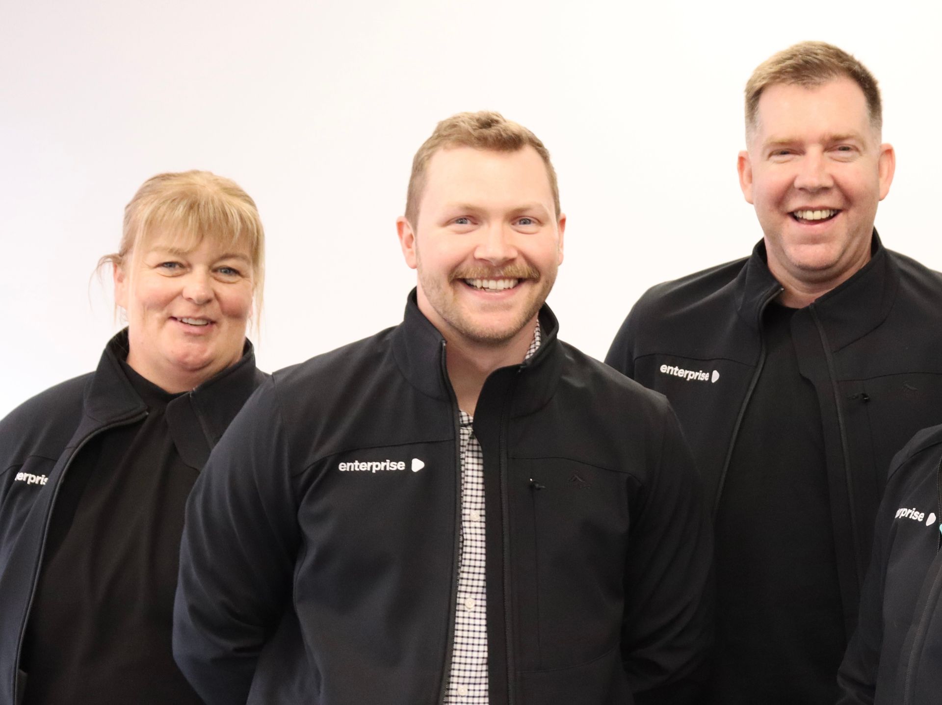 Smiling people in black jackets.