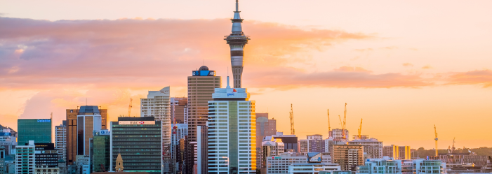 Sky Tower and city skyline at sunset in Auckland, New Zealand.