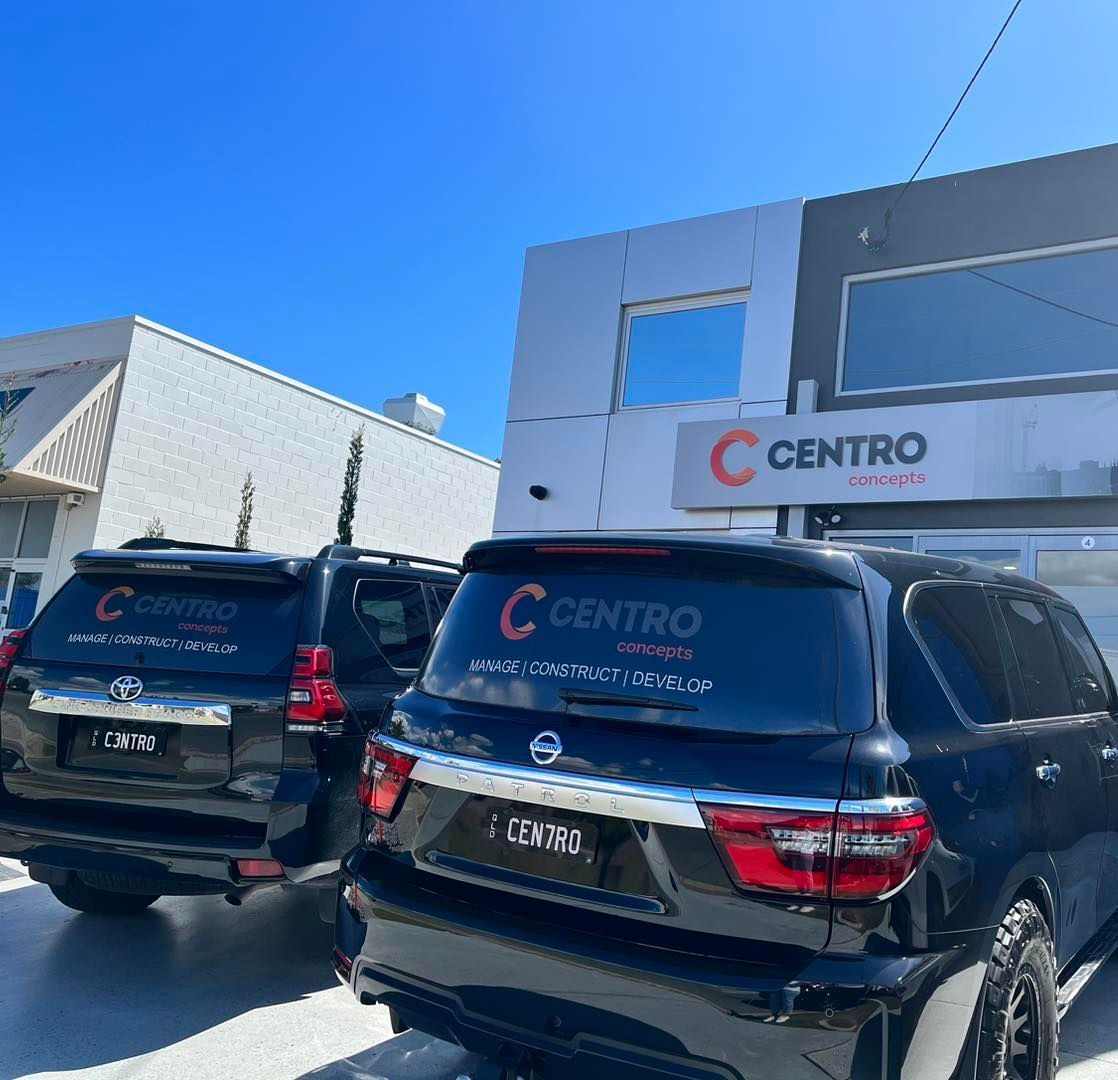 Two black SUVs parked outside a building with the 