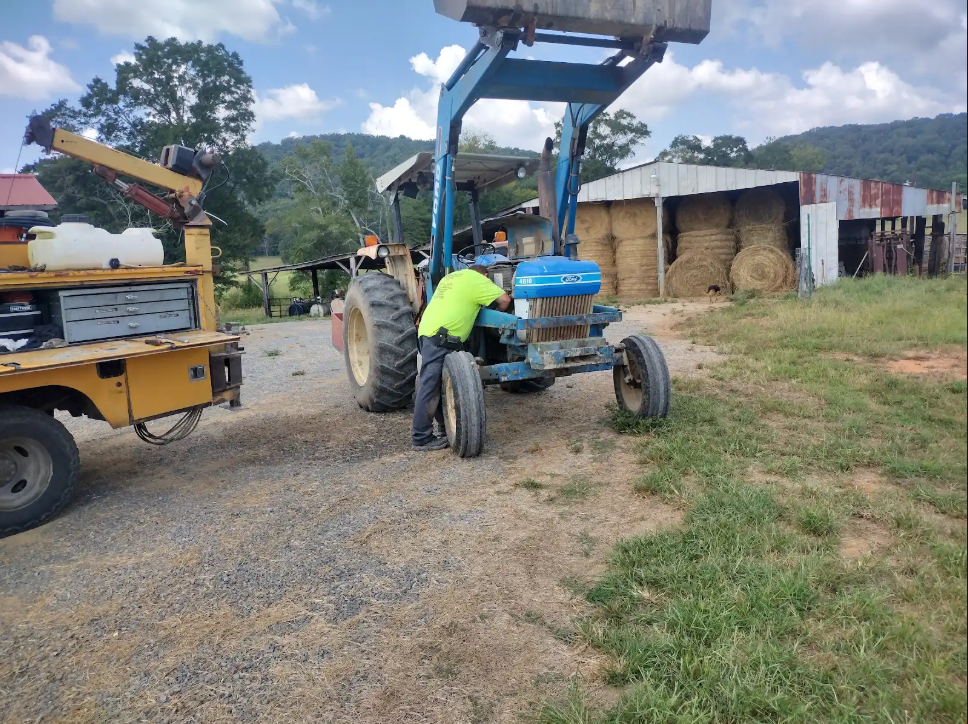 Technician repairing excavator on job site