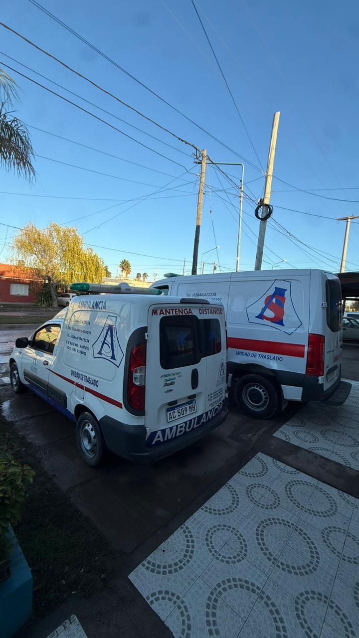 Dos furgonetas blancas de reparto con logotipos de empresas aparcadas en una calle bajo un cielo azul despejado.