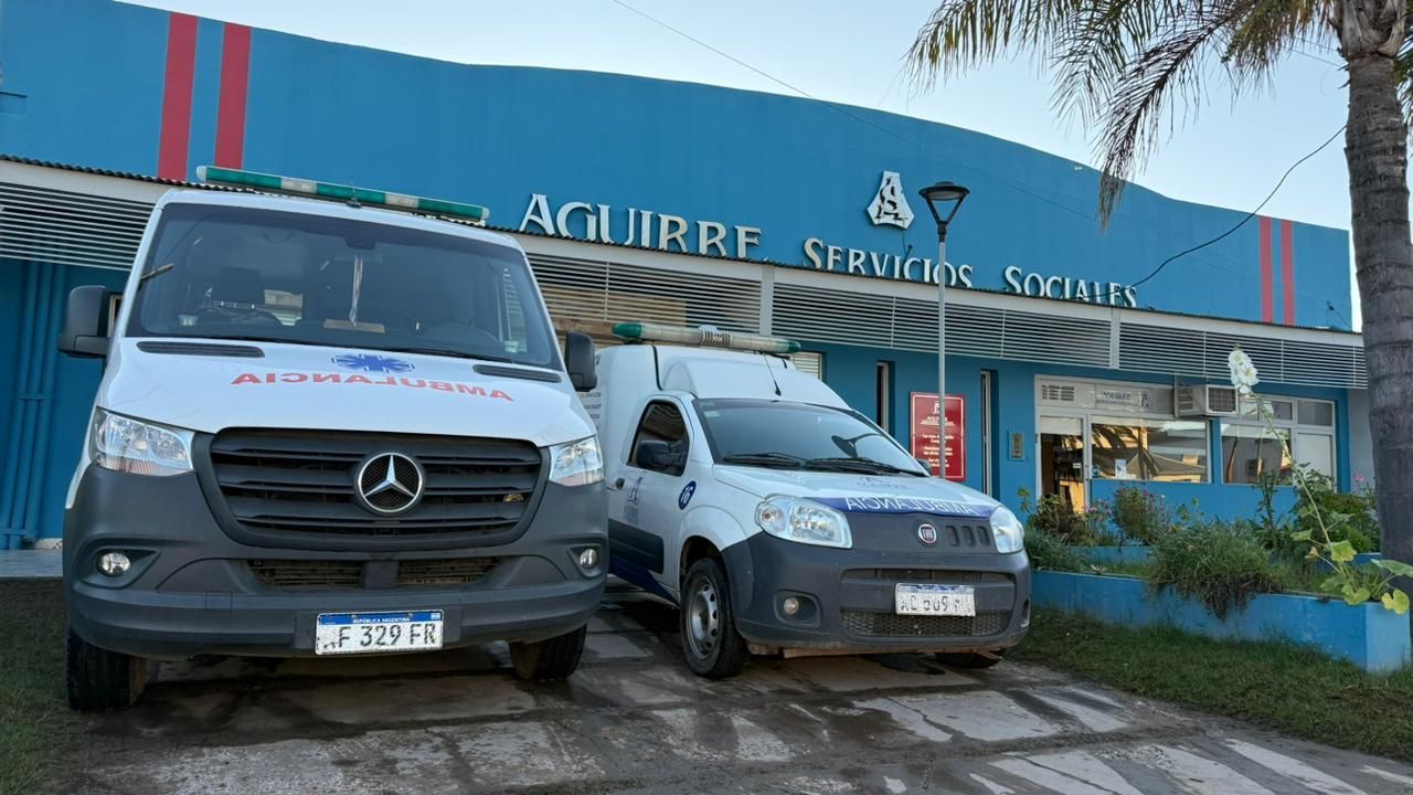 Dos furgonetas blancas de servicio aparcadas frente al centro de servicio Aguirre, que tiene una fachada azul.