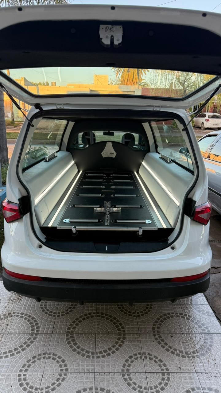 Maletero tipo hatchback abierto con asientos traseros plegados y separador de carga en una camioneta familiar blanca.