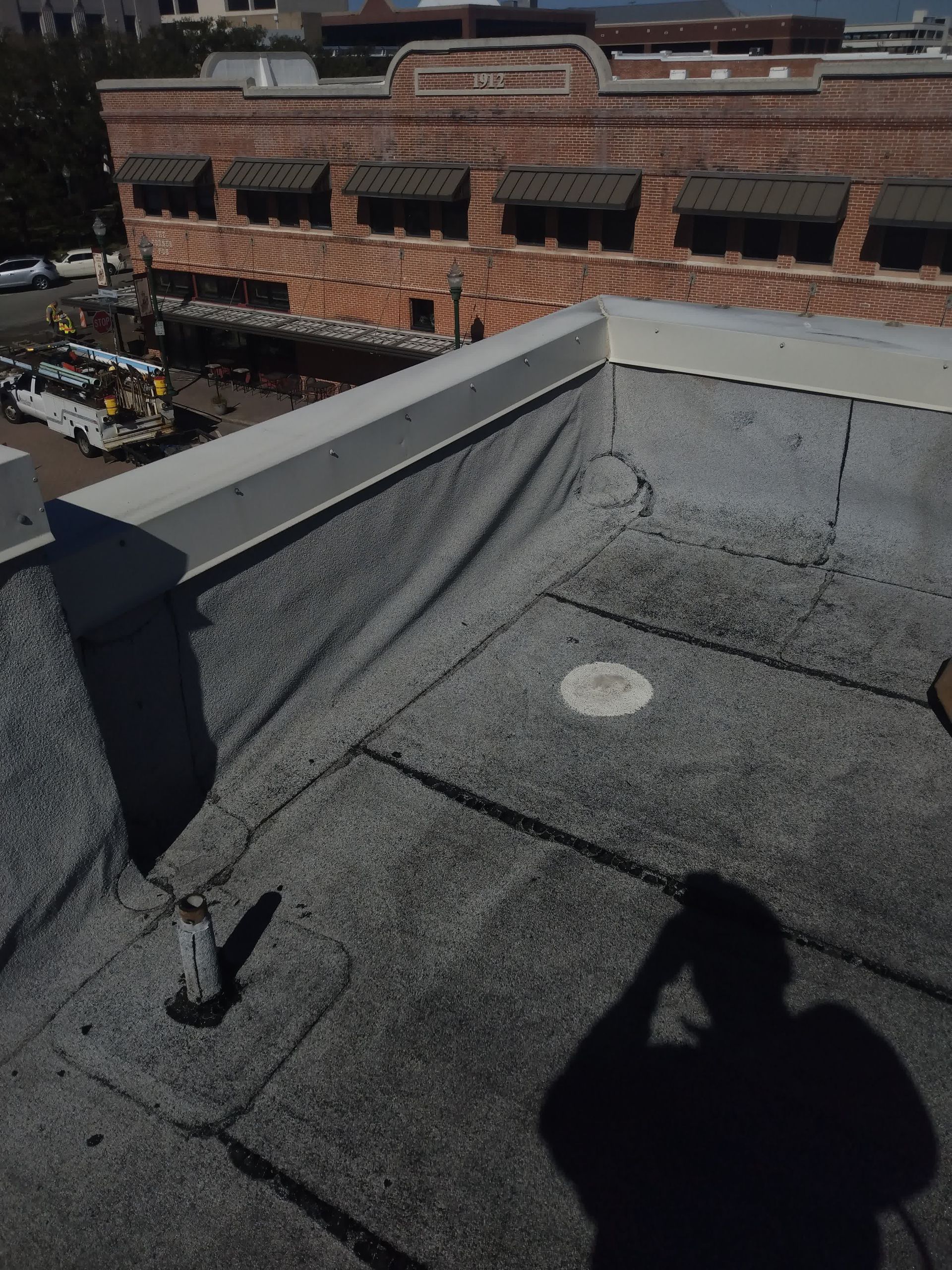 two men are working on a roof with a torch
