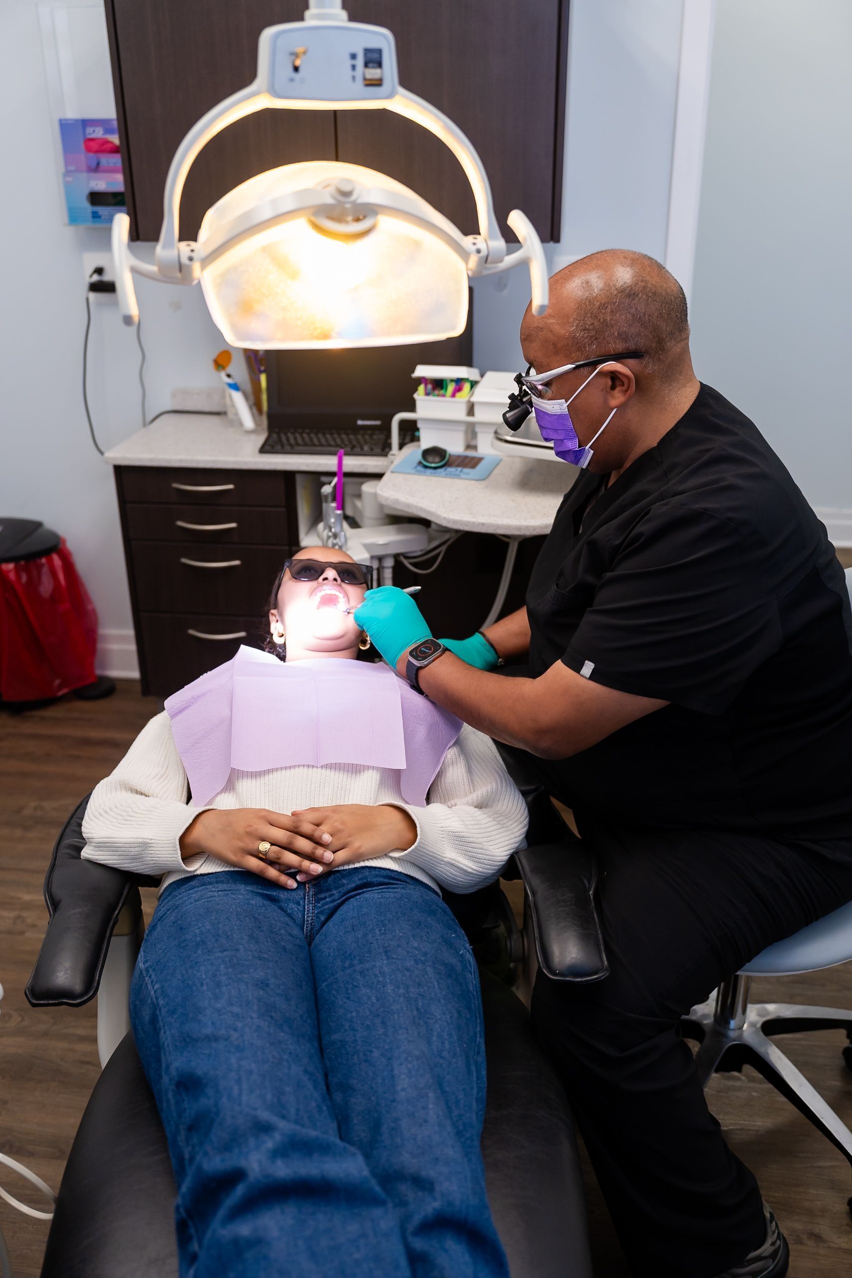 Dentist treating a patient under the exam light at Namu Dental Care, an emergency dentist in Stafford, VA