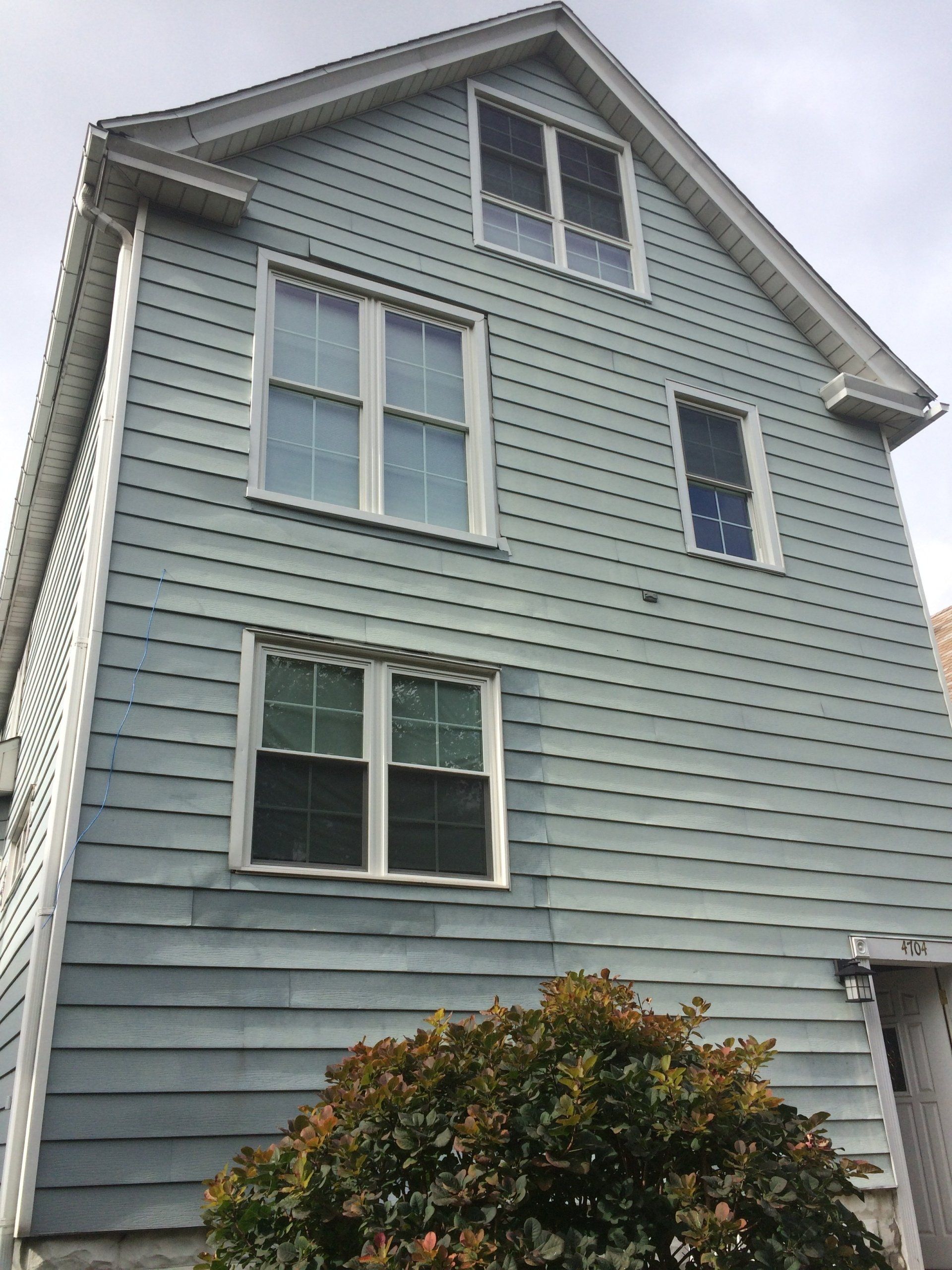 A large house with a lot of windows and a tree in front of it.