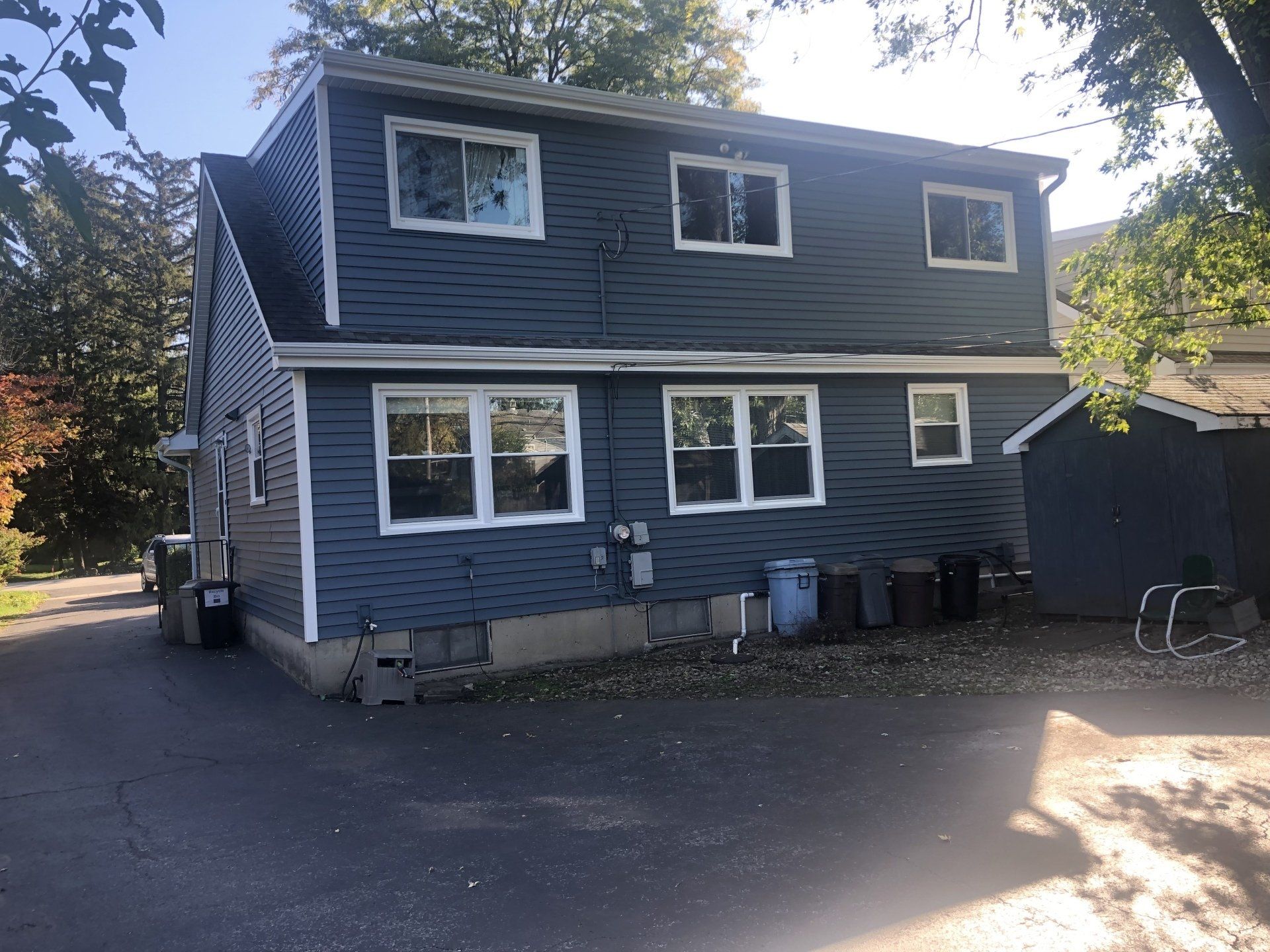 A blue house with a lot of windows and a garage.