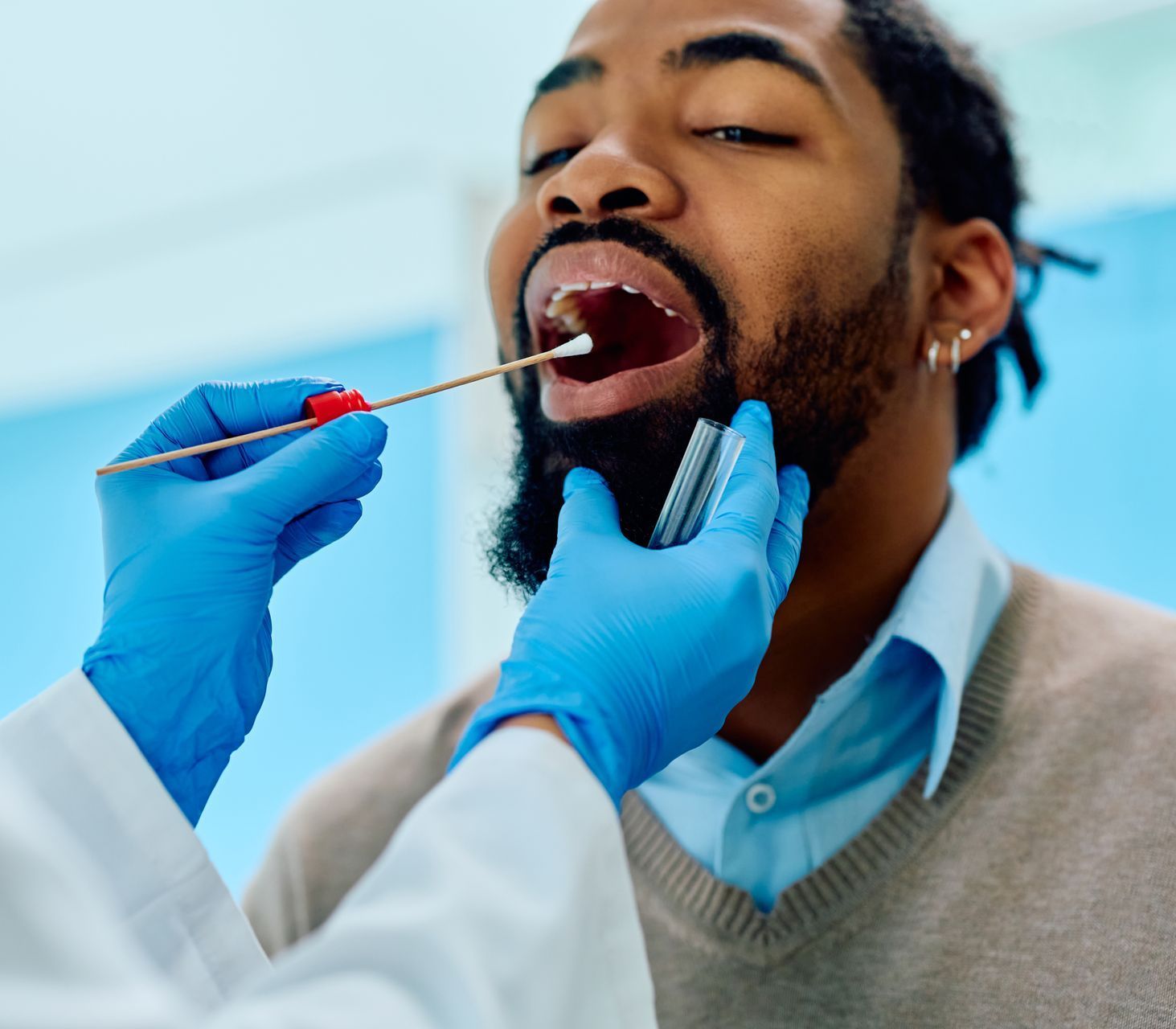 Get oral microbiome testing done by our biological dentist in Somerset, NJ. man at dentist getting mouth swabbed | Oral microbiome testing from our biological dentist