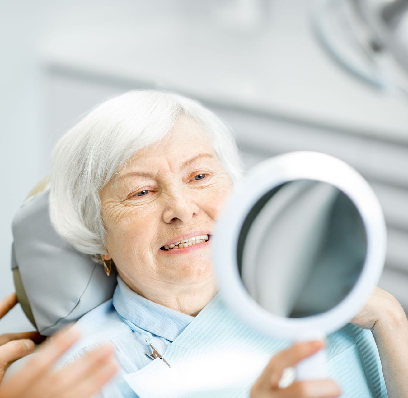 Get dentures, crowns, fillings, bridges, and fix sleep apnea in Somerset, NJ Fix a broken tooth with restorative dental care in Somerset NJ | Woman smiling in mirror | dentures and more