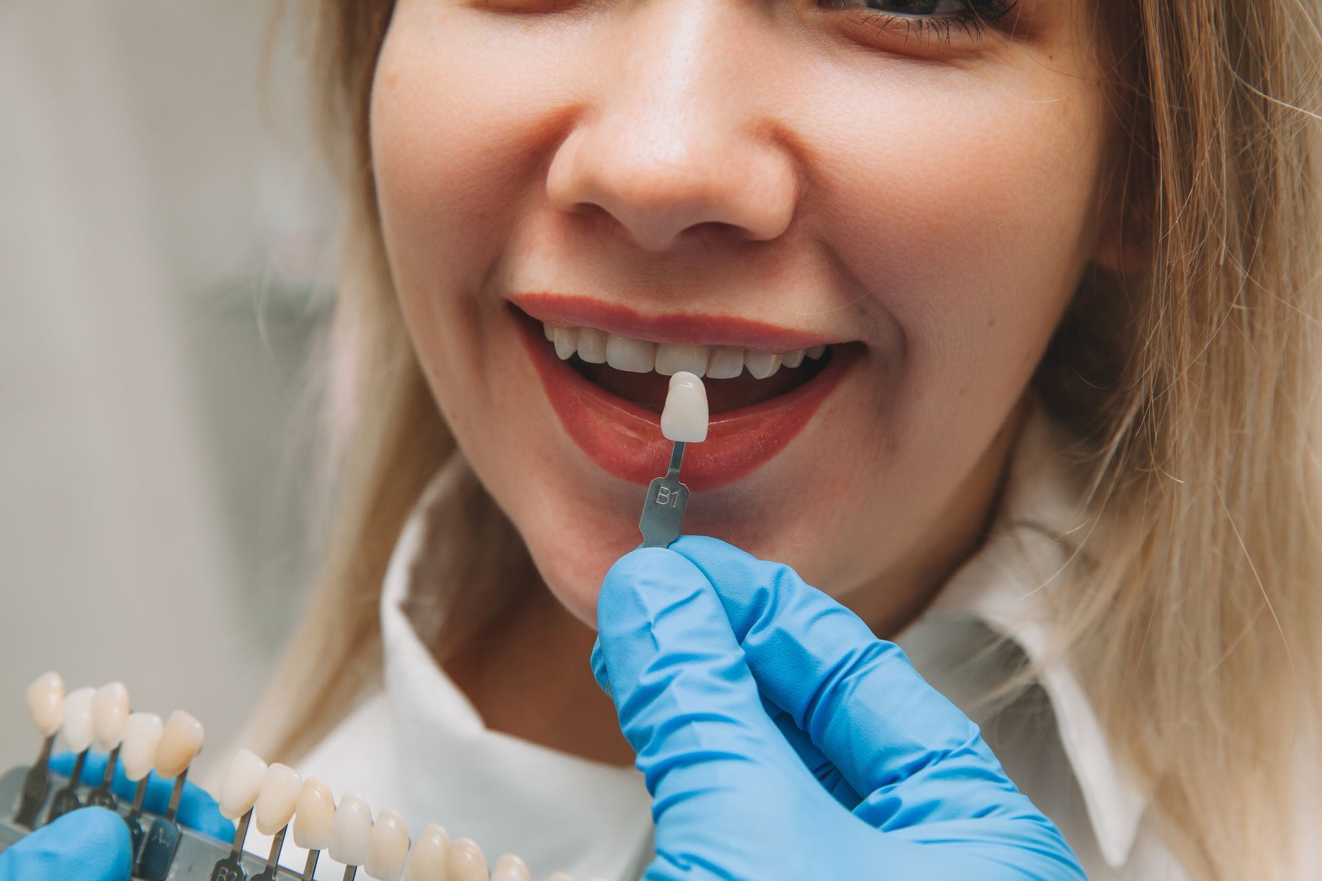 Cosmetic Dental Veneers in Somerset, NJ woman with veneers held up to mouth | Cosmetic dental veneers | Cosmetic Dentist Somerset NJ