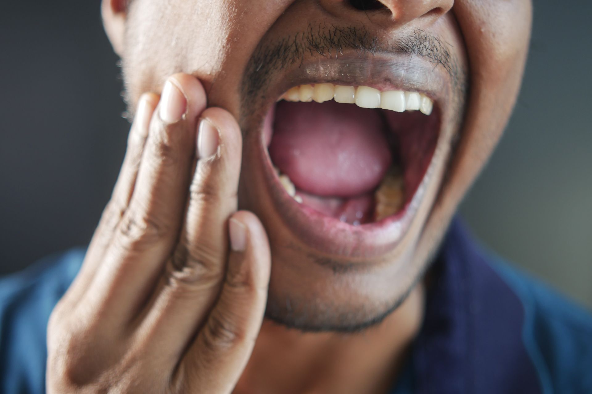 Same day emergency family dentist near Somerset, NJ. Man holding mouth | Same day emergency dentist near Somerset, NJ