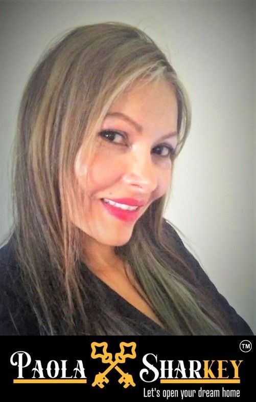 Paola Sharkey smiles; real estate agent headshot with logo,