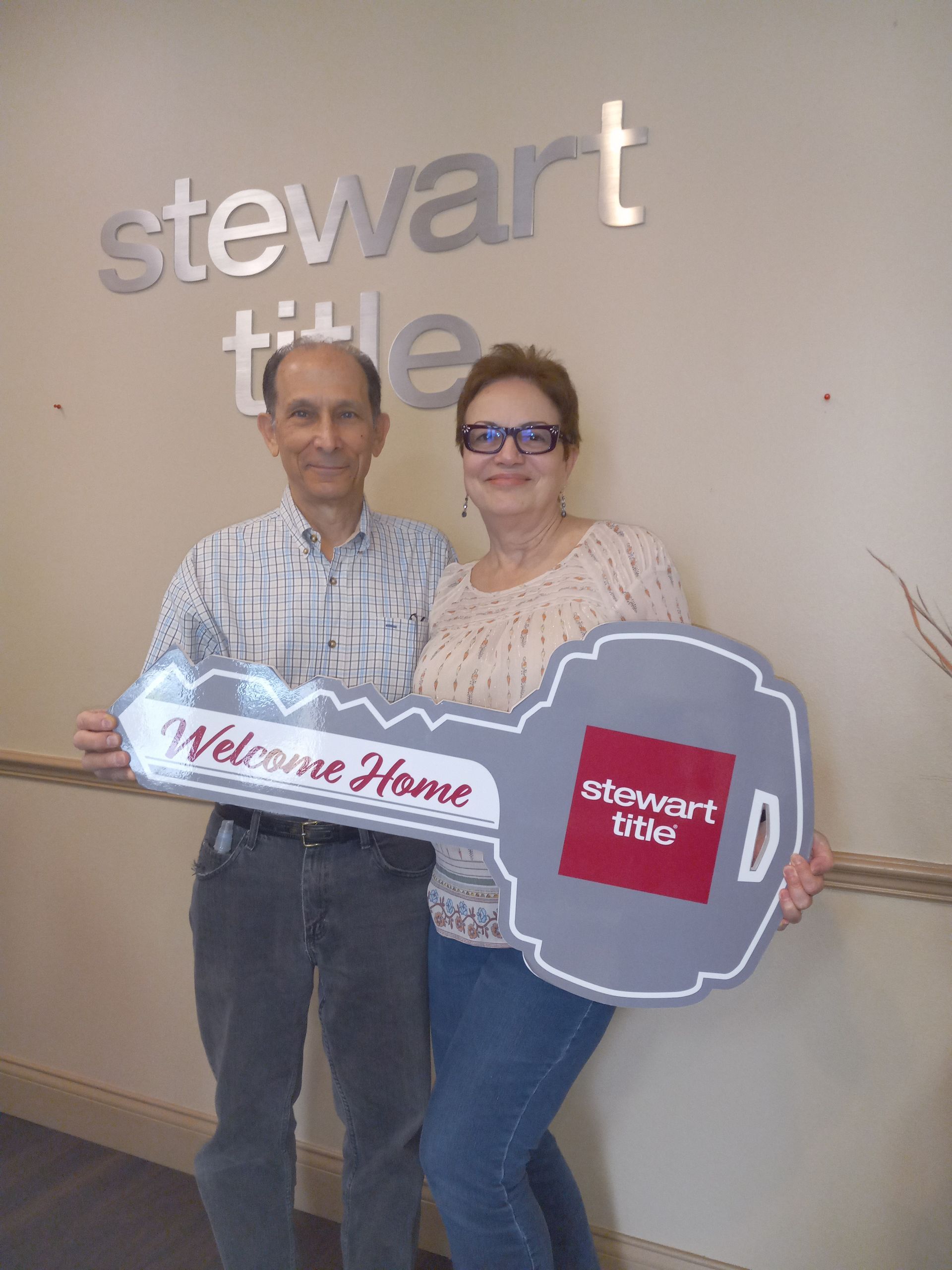 Couple holding large key prop that says