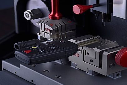 A car key is being cut on a machine.