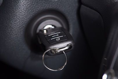 A car key is sitting in the ignition of a car.