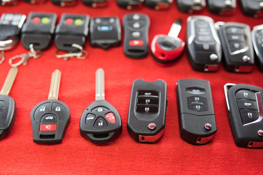 A bunch of car keys are sitting on a red table.
