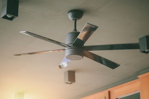 Modern ceiling fan mounted on a living room ceiling, used to help circulate warm air during fall and