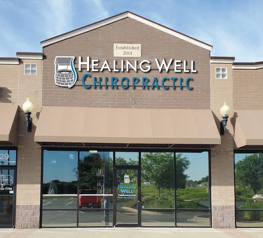 Healing Well Chiropractic storefront with tan facade, glass doors, and blue sign in a shopping center
