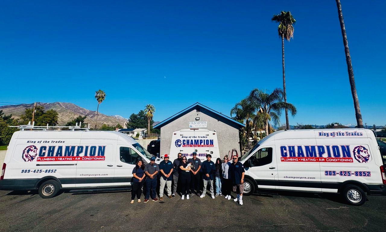 A group of people are posing for a picture in front of two champion vans.