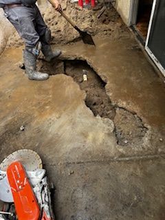 A man is digging a hole in the ground with a shovel.