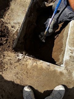 A person is digging a hole in the ground with a shovel.