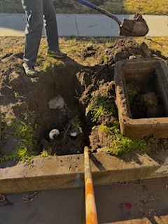 A man is digging a hole in the ground with a shovel.
