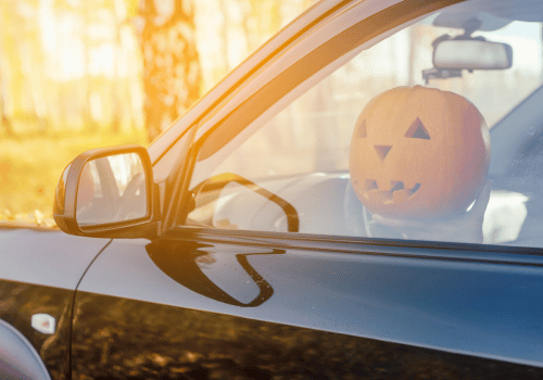 Black SUV with a jack-o'-lantern visible through the driver's side window