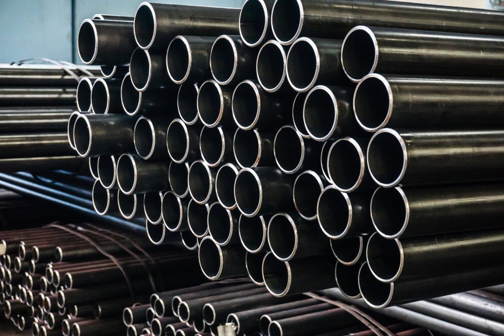 A Bunch of Metal Pipes Are Stacked on Top of Each Other — DnA Steel Direct in Ciccone, NT