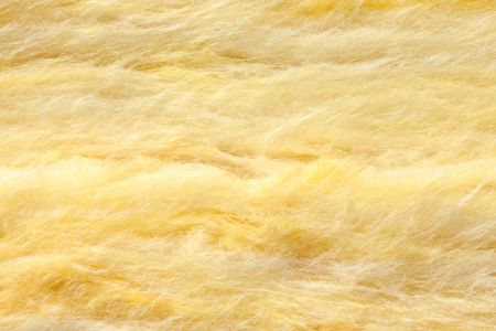 Isolant en fibre de verre jaune, un matériau de construction moelleux et texturé.