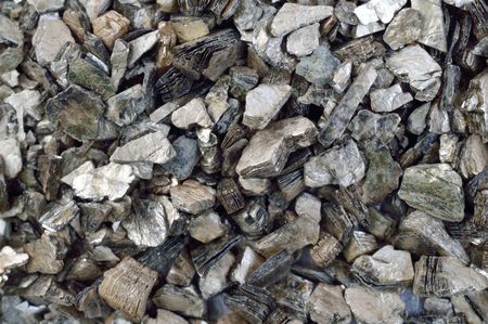 Isolant en cellulose grise entre des bandes de bois, probablement dans un plancher ou un plafond.