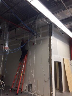 A man is standing on a ladder in a room.