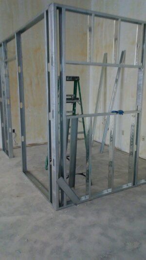 A room with a metal frame and a ladder in it.