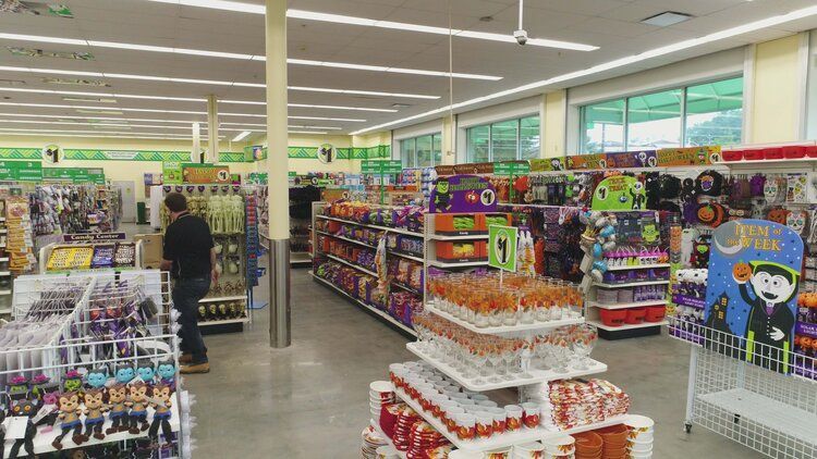 A man is walking down the aisle of a store.