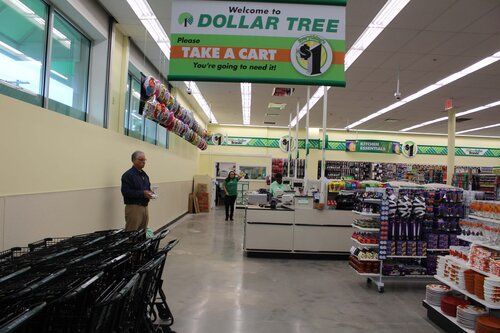 A dollar tree store with a sign that says take a cart
