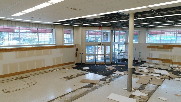 A large empty room with a door and a lot of windows.