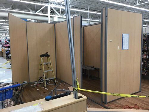 A ladder is sitting in the middle of a room in a store.