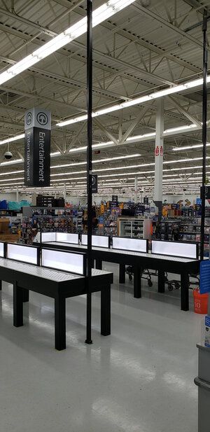 A large store with a lot of tables and signs hanging from the ceiling.