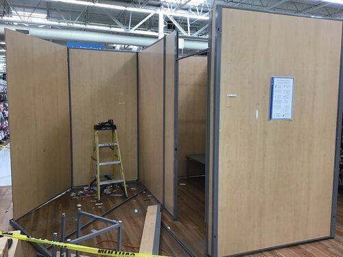 A ladder is sitting in the middle of a room with wooden walls.